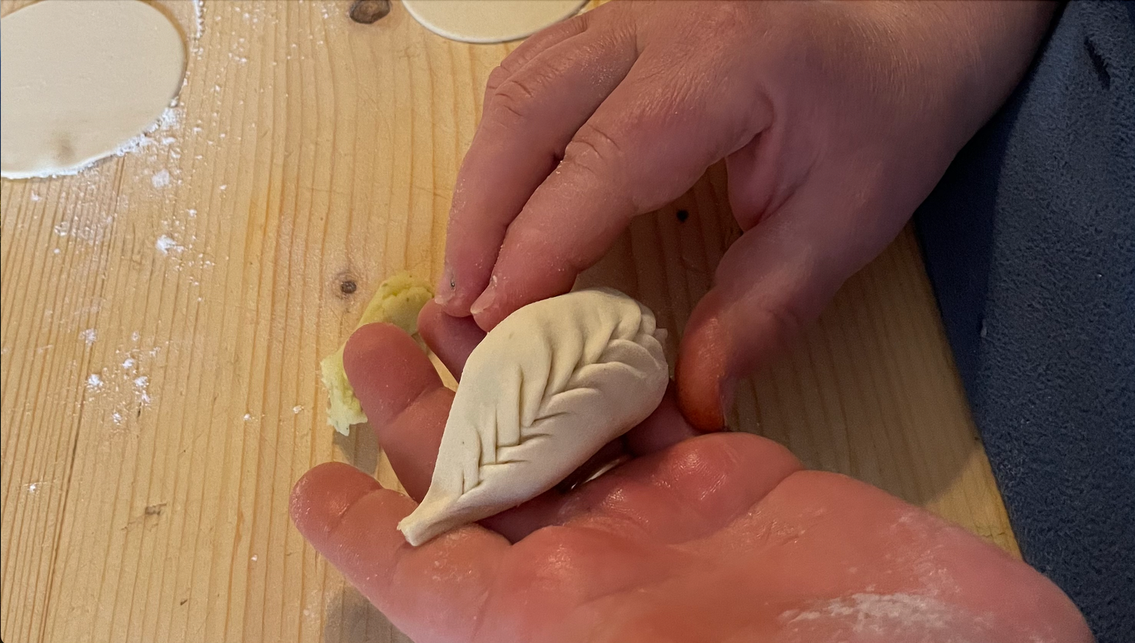 2 hands are holding one sardinia typical ravioli, , called culurgiones